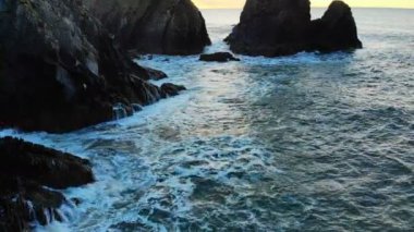 dağ kayalıklarla ve 4k alacakaranlıkta deniz ile plaj