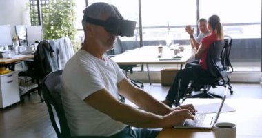 Erkek executive Office 4 k masada sanal gerçeklik kulaklık ve bir dizüstü bilgisayar kullanarak
