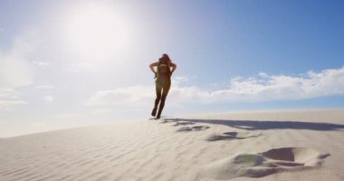 Güneşli bir günde 4 k çölde yürüyen sırt çantası kadınla arkadan görünüş