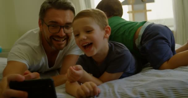 Πατέρας Και Παιδιά Λήψη Selfie Στο Κρεβάτι Στο Σπίτι — Αρχείο Βίντεο
