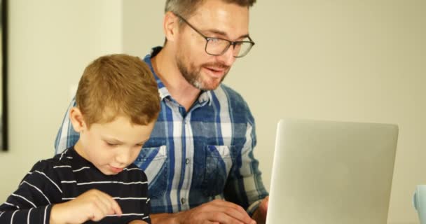 Père Fils Utilisant Ordinateur Portable Tablette Numérique Dans Salon Maison — Video