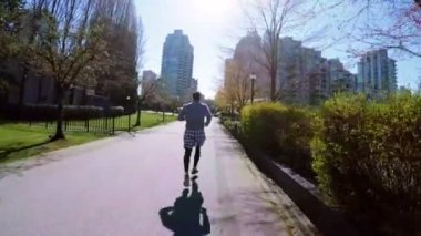 Adam şehirde güneşli bir günde 4 k koşu