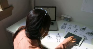 Konsantre Moda Tasarımcısı tasarım stüdyosu 4 k elbise çizimler üzerinde çalışıyor