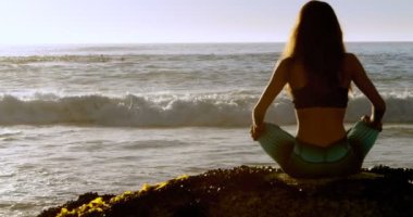 Arkadan Görünüş uygun kadının 4 k kumsalda yoga gerçekleştirme