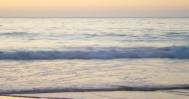 4 k gün batımında sahilde inişli çıkışlı dalgalar yakın çekim
