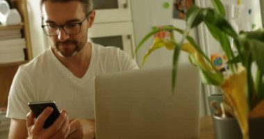 Mutfakta ev 4 k cep telefonu kullanan adam