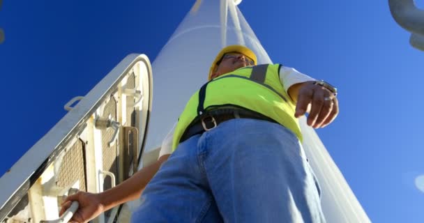 男工程师站在风机在风电场在一个晴朗的日子4K — 图库视频影像