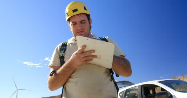 Ingeniero Masculino Escribiendo Portapapeles Parque Eólico Día Soleado — Vídeos de Stock