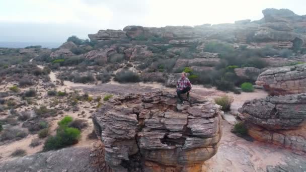 Uomo Seduto Sulla Formazione Rocciosa Nel Paesaggio — Video Stock