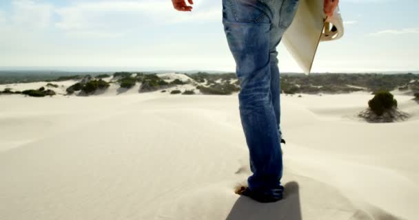 Rückansicht Eines Mannes Der Mit Sandbrett Der Wüste Läuft — Stockvideo