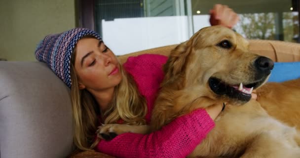 Молодая Женщина Целует Свою Собаку Диване Дома — стоковое видео