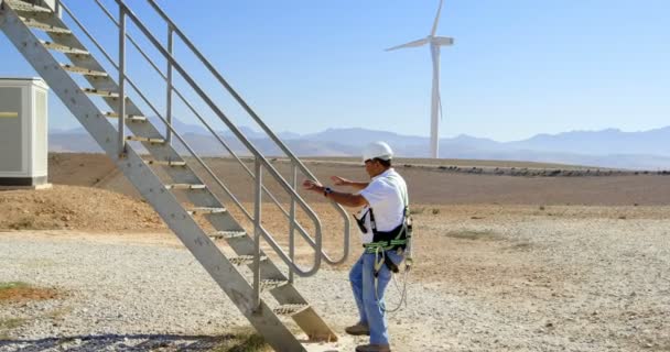 Ingeniero Masculino Caminando Arriba Parque Eólico Día Soleado — Vídeos de Stock