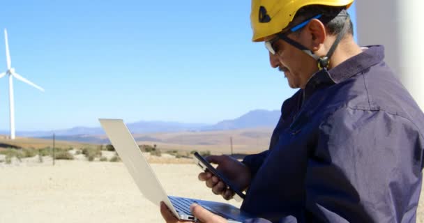 Rüzgar Çiftliği Içinde Laptop Üzerinde Çalışırken Cep Telefonuyla Erkek Mühendis — Stok video