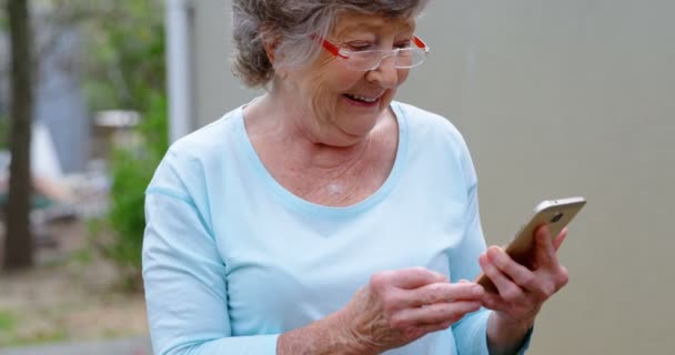 Mujer Mayor Sonriente Usando Teléfono Móvil — Vídeos de Stock