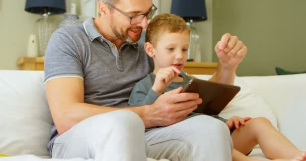 Πατέρας Και Γιος Χρησιμοποιώντας Ψηφιακό Tablet Στον Καναπέ Στο Σπίτι — Αρχείο Βίντεο