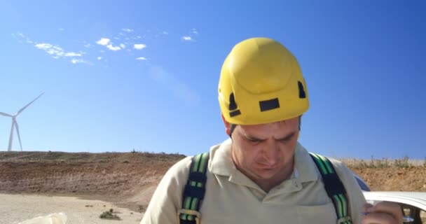 Ingeniero Masculino Escribiendo Portapapeles Parque Eólico Día Soleado — Vídeos de Stock