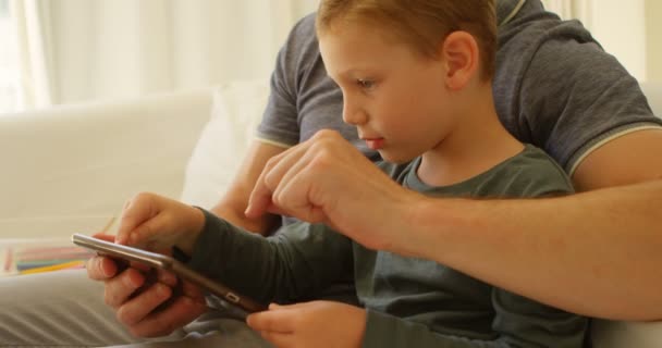 Gros Plan Père Fils Aide Une Tablette Numérique Sur Canapé — Video