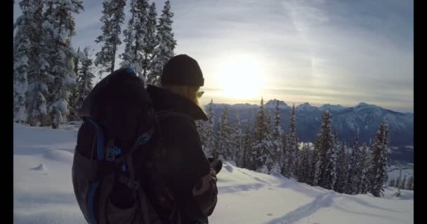 妇女与背包使用她的电话在雪覆盖的山在冬天4K — 图库视频影像