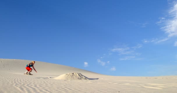 Άνθρωπος Που Εκτελεί Ένα Άλμα Ενώ Sand Επιβίβαση Στην Έρημο — Αρχείο Βίντεο