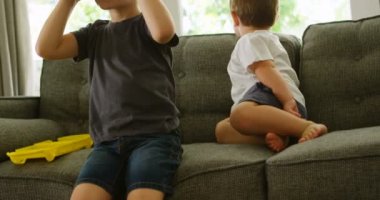 4 k kardeş evde sanal gerçeklik kulaklık kullanarak süre kanepede oturan çocuk