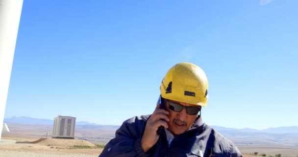 Ingeniero Masculino Hablando Por Teléfono Móvil Parque Eólico Día Soleado — Vídeos de Stock