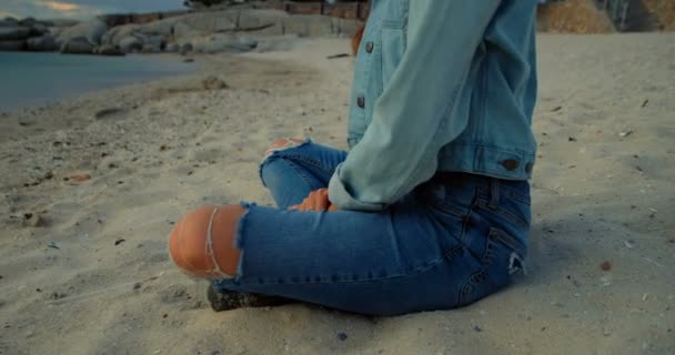 のビーチに座っている美しい女性 — ストック動画