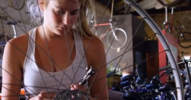 Güzel kadın iş dükkanında 4 k Bisiklet tamir