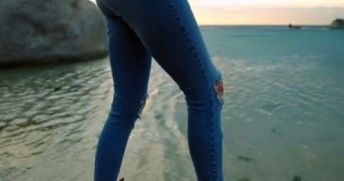 4 k plajda kayada duran güzel kadın