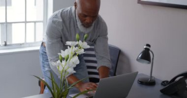 Office 4 k masada dizüstü bilgisayar kullanırken telefonda konuşurken işadamı