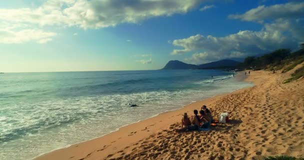 在阳光明媚的日子里 游客们坐在沙滩上4K — 图库视频影像