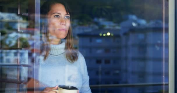 コーヒー カップ 自宅の窓の近くに立っている女性 — ストック動画