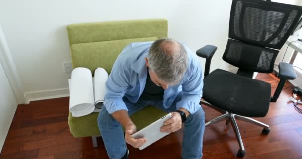 Hombre Usando Tableta Digital Mientras Trabaja Planos Casa — Vídeo de stock