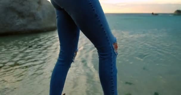 美丽的女人站在岩石海滩4K — 图库视频影像