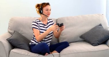 Kadın kanepe beyaz arka plan 4 k joystick oyun oynamak kulaklık ile