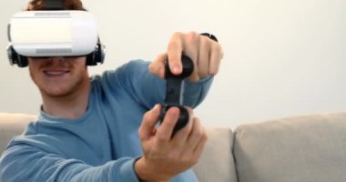 Beyaz arka plan 4 k Divan sanal gerçeklik kulaklık joystick oyun oynuyor adam