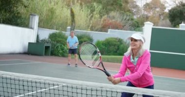 Gülümseyen kadın kıdemli ve Tenis Kortu 4 k tenis oynayan adam