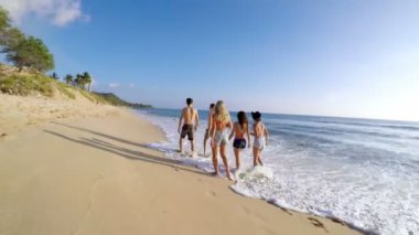 Güneşli bir günde 4 k kumsalda yürüyen turist