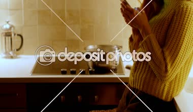 Güzel kadın mutfakta ev 4 k bir cep telefonu kullanarak