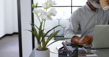 Office 4 k masada dizüstü bilgisayar kullanırken kahve olan işadamı