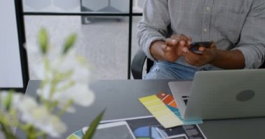 Office 4 k masada cep telefonu kullanarak işadamı gülümseyen