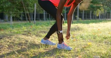 Genç kadın atlet Ayakkabı bağcıklarımı orman 4 k bağlama