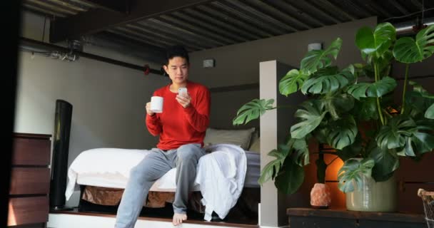 Hombre Con Taza Café Usando Teléfono Móvil Dormitorio Casa — Vídeos de Stock