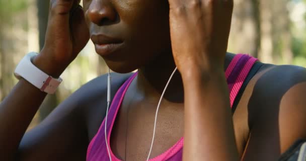 Primer Plano Atleta Femenina Sosteniendo Sus Auriculares Bosque — Vídeo de stock