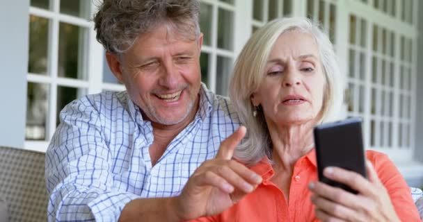 Seniorenpaar Diskutiert Handy Auf Der Veranda Hause — Stockvideo