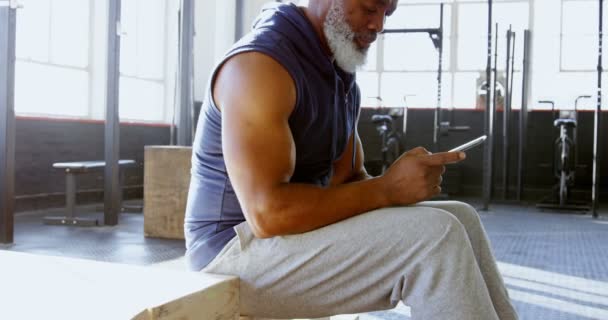 Vista Lateral Del Hombre Mayor Utilizando Teléfono Inteligente Gimnasio — Vídeos de Stock