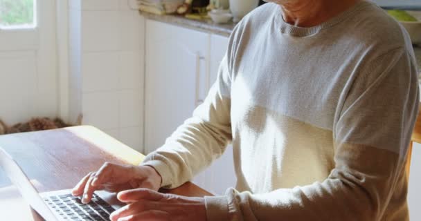 Hombre Mayor Usando Ordenador Portátil Cocina Casa — Vídeos de Stock