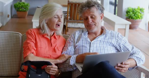 Старшая Пара Обсуждают Ноутбуком Диване Доме — стоковое видео