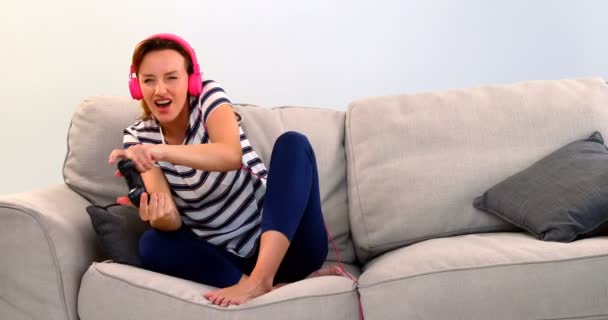 Frau Mit Headset Spielt Joystick Spiel Auf Sofa Vor Weißem — Stockvideo