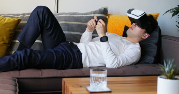 Hombre Acostado Sofá Jugando Videojuegos Con Auriculares Realidad Virtual Casa — Vídeos de Stock