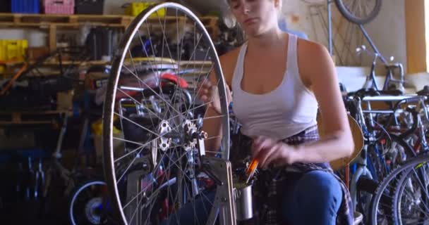 Mulher Bonita Reparando Bicicleta Oficina — Vídeo de Stock